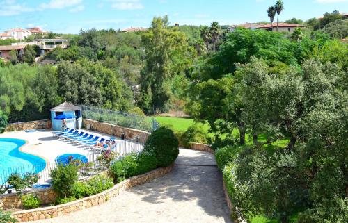 una vista sul soffitto di una piscina con sedie e alberi di Villaggio Smeralda by Sardegna Smeralda Suite a Porto Rotondo