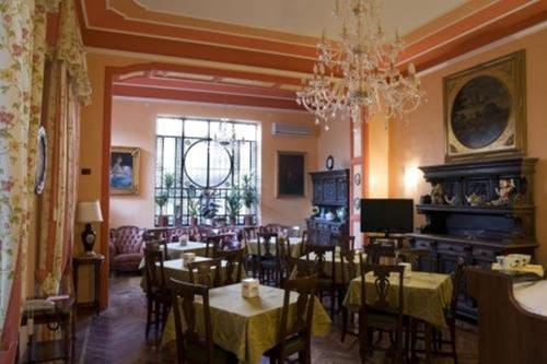 uma sala de jantar com mesas e cadeiras e um lustre em Hotel Principi D'Acaja em Turim