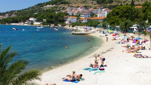 a group of people on a beach near the water at Apartments Renata in Trogir