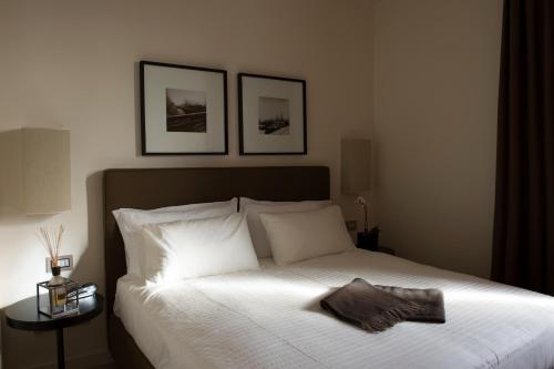 a bedroom with a white bed with two pictures on the wall at Marina Place Resort in Genova