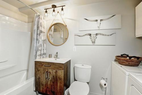 Un baño con inodoro, lavabo y espejo. en Condo 20 Chemin des Adirondack by Les Chalets Alpins, en Stoneham