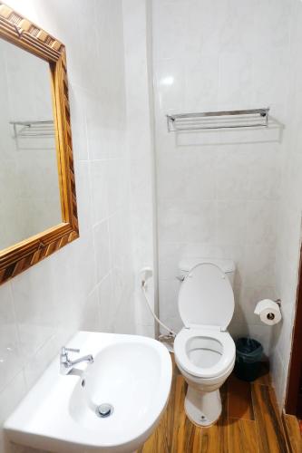 a bathroom with a white toilet and a sink at Aphilapa Residence in Chiang Mai