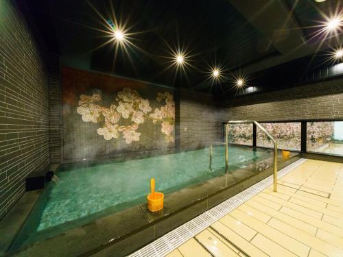 a large swimming pool in a building with at Super Hotel Lohas Ikebukuro-Eki Kitaguchi in Tokyo