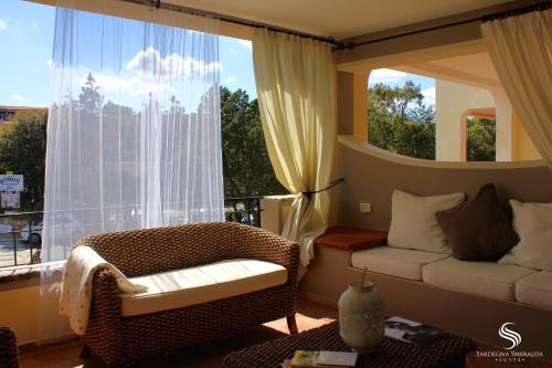 a living room with a couch and a large window at Villaggio Smeralda by Sardegna Smeralda Suite in Porto Rotondo