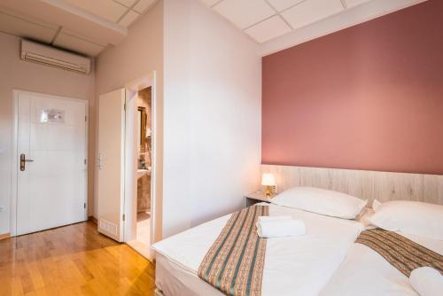 a bedroom with a large white bed in a room at Boutique Hostel Livia in Metković