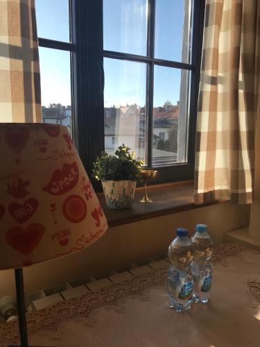 two bottles of water sitting next to a window at Stary Spichrz Kawiarnia & Noclegi in Chełmno