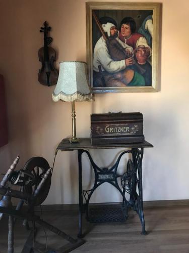 a table with a lamp and a painting on the wall at Stary Spichrz Kawiarnia & Noclegi in Chełmno