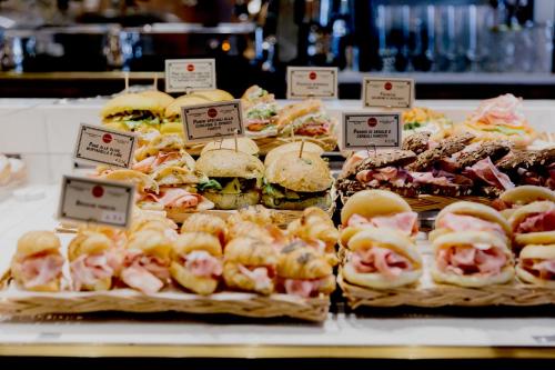 Una exhibición de sándwiches y pasteles en una panadería. en Locanda Pandenus Brera, en Milán