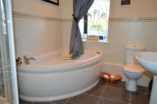 uma casa de banho com uma banheira, um WC e um lavatório. em Queens View em Dunoon