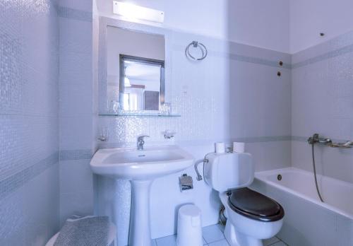 a white bathroom with a sink and a toilet at Kerkis Bay in Marathokampos