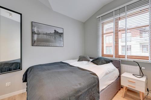 biała sypialnia z łóżkiem i oknem w obiekcie La Rose - Luxury Neptun Park w Gdańsku