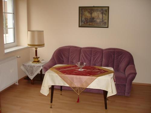 um sofá roxo com uma mesa numa sala de estar em Ferienwohnung Schob em Dyrotz