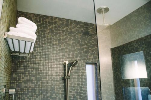 a bathroom with a shower with towels on the wall at Modern Hotel in Boise
