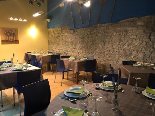 comedor con mesas y sillas y pared de piedra en Hotel Torrepalacio, en Proaza