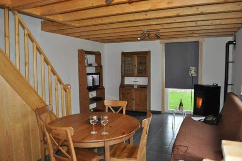 sala de estar con mesa de madera y sofá en Bungalow, en Froidchapelle