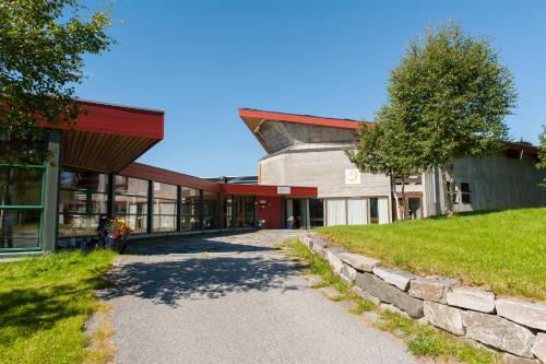 a building with a stone pathway in front of it at Rauland Vandrerhjem Akademiet in Rauland