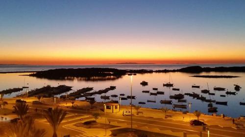 a marina with boats in the water at sunset at B&B L'Isola in Porto Cesareo