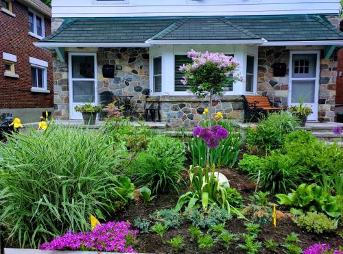 a garden in front of a house with flowers at Elcho explOre Ottawa in Ottawa