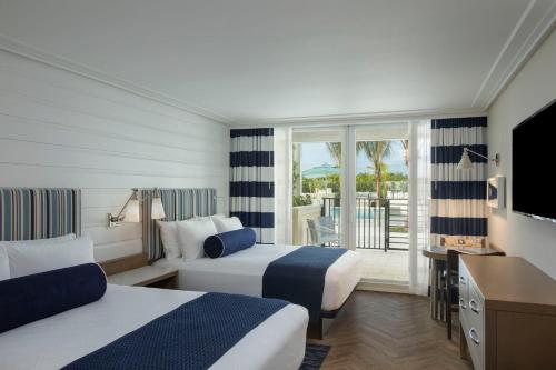 um quarto de hotel com duas camas e uma televisão em Hutchinson Shores Resort & Spa em Jensen Beach