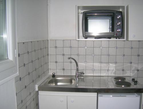 La cuisine est équipée d'un évier et d'un four micro-ondes. dans l'établissement Appartements Villa Odette, à Bagnoles-de-l'Orne