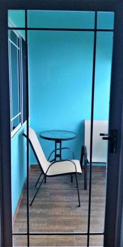 a glass room with a table and a chair at Bailey's Bed and Breakfast in Runaway Bay