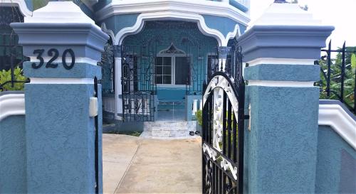 a blue gate in front of a house at Bailey's Bed and Breakfast in Runaway Bay