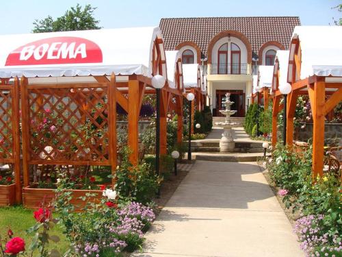 a garden center with a fence and flowers at Vila Boema in Marghita