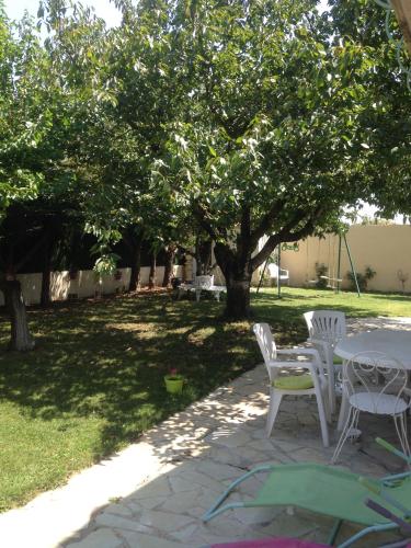 a patio with a table and chairs under a tree at Charmant Studio à Uchaud in Uchaud