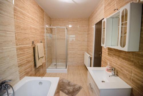 a bathroom with a tub and a sink and a shower at Dumbrava Ursului in Zărneşti
