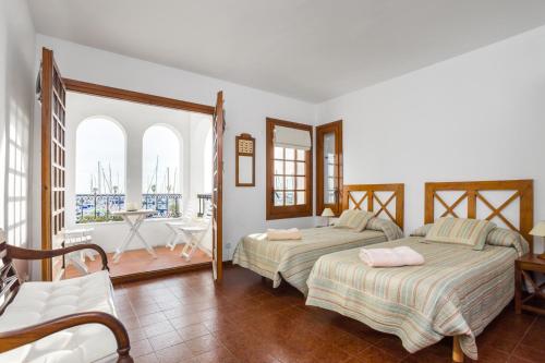 シッチェスにあるHHBCN Port de Sitgesのベッドルーム1室(ベッド2台付)、バルコニーが備わります。