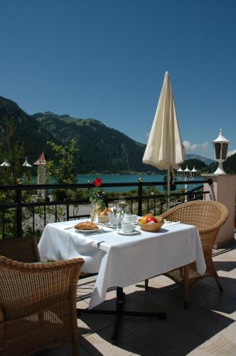 uma mesa com comida e um guarda-chuva num pátio em Romantik Resort & SPA Der Laterndl Hof em Haldensee