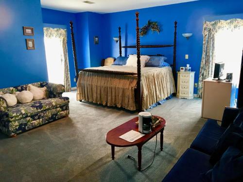 Versailles的住宿－Rabbit Creek Bed & Breakfast，一间拥有蓝色墙壁的卧室,配有一张床和一张桌子