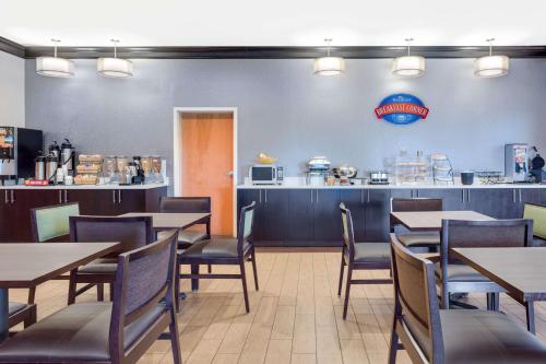 una sala da pranzo con tavoli, sedie e un bancone di Baymont by Wyndham Augusta Riverwatch ad Augusta