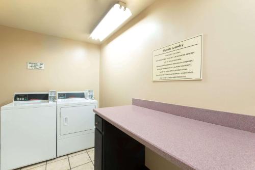 a laundry room with a washer and dryer at Baymont by Wyndham Louisville East in Louisville
