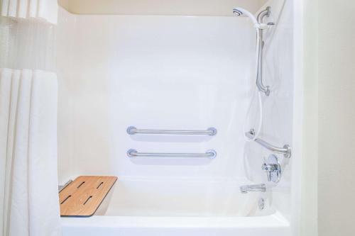 een badkamer met een douche en een bad met een wastafel bij Baymont by Wyndham Hot Springs in Hot Springs