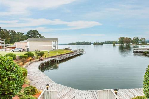 a dock next to a lake with a house at Baymont on the lake by Wyndham Hot Springs in Hot Springs