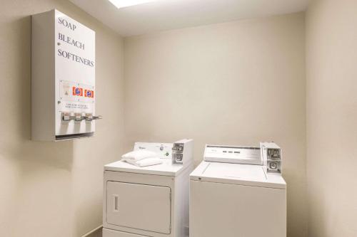 a laundry room with a washer and dryer at Baymont by Wyndham Galveston in Galveston