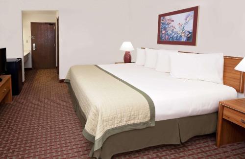a large white bed in a hotel room at Baymont by Wyndham St. Joseph/Stevensville in Stevensville