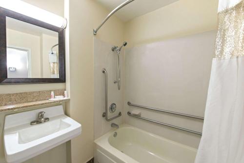 a white bathroom with a sink and a shower at Baymont by Wyndham Louisville East in Louisville