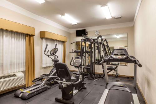 a gym with several tread machines in a room at Baymont by Wyndham Galveston in Galveston