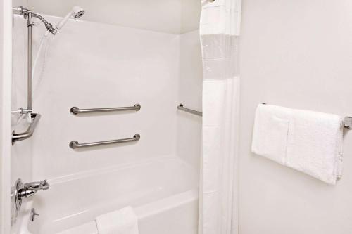 a white bathroom with a shower and a tub at Baymont by Wyndham St. Joseph/Stevensville in Stevensville