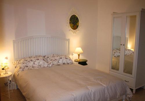 a bedroom with a large white bed and a mirror at Casa Sofì in Tolentino