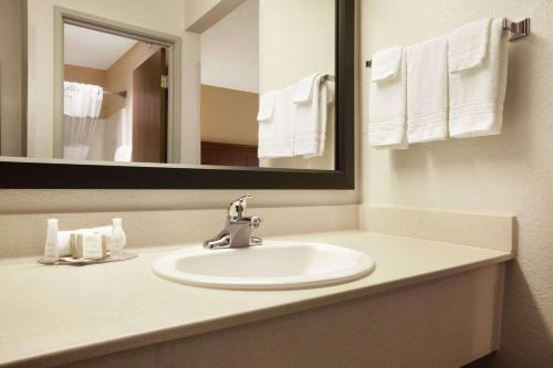 a bathroom with a sink and a mirror at Baymont by Wyndham Sioux Falls in Sioux Falls