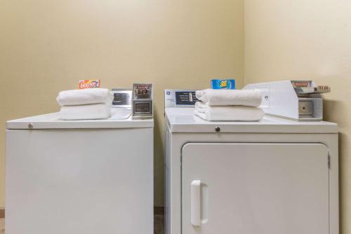 a room with two tables with towels on top of a refrigerator at Baymont by Wyndham Wichita Falls in Wichita Falls
