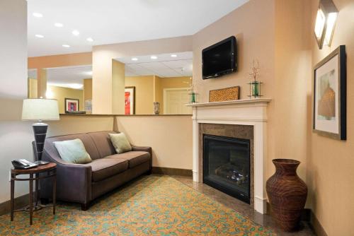 a living room with a couch and a fireplace at Baymont by Wyndham Denver International Airport in Denver