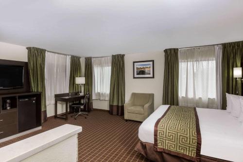 A bed or beds in a room at Baymont by Wyndham Louisville South I 65