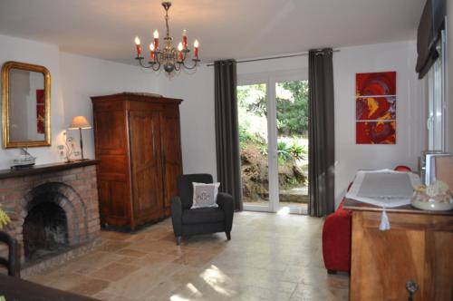 Una sala de estar con chimenea y una silla. en Villa farniente, en Le Lavandou