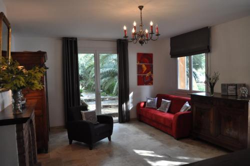 a living room with a red couch and a chair at Villa farniente in Le Lavandou