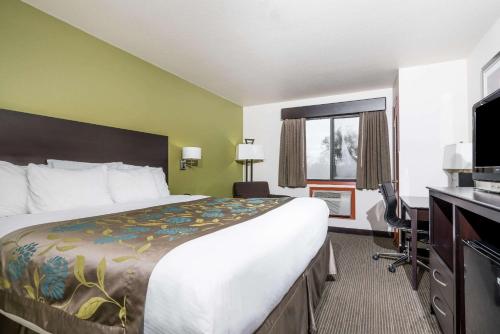 a hotel room with a large bed and a television at Baymont by Wyndham Eau Claire WI in Eau Claire