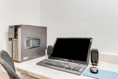 a laptop computer sitting on a desk next to a cpu at Baymont by Wyndham Midland Airport in Midland